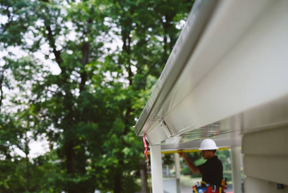 Professional installing mesh gutter guards on a Nashville home roofline